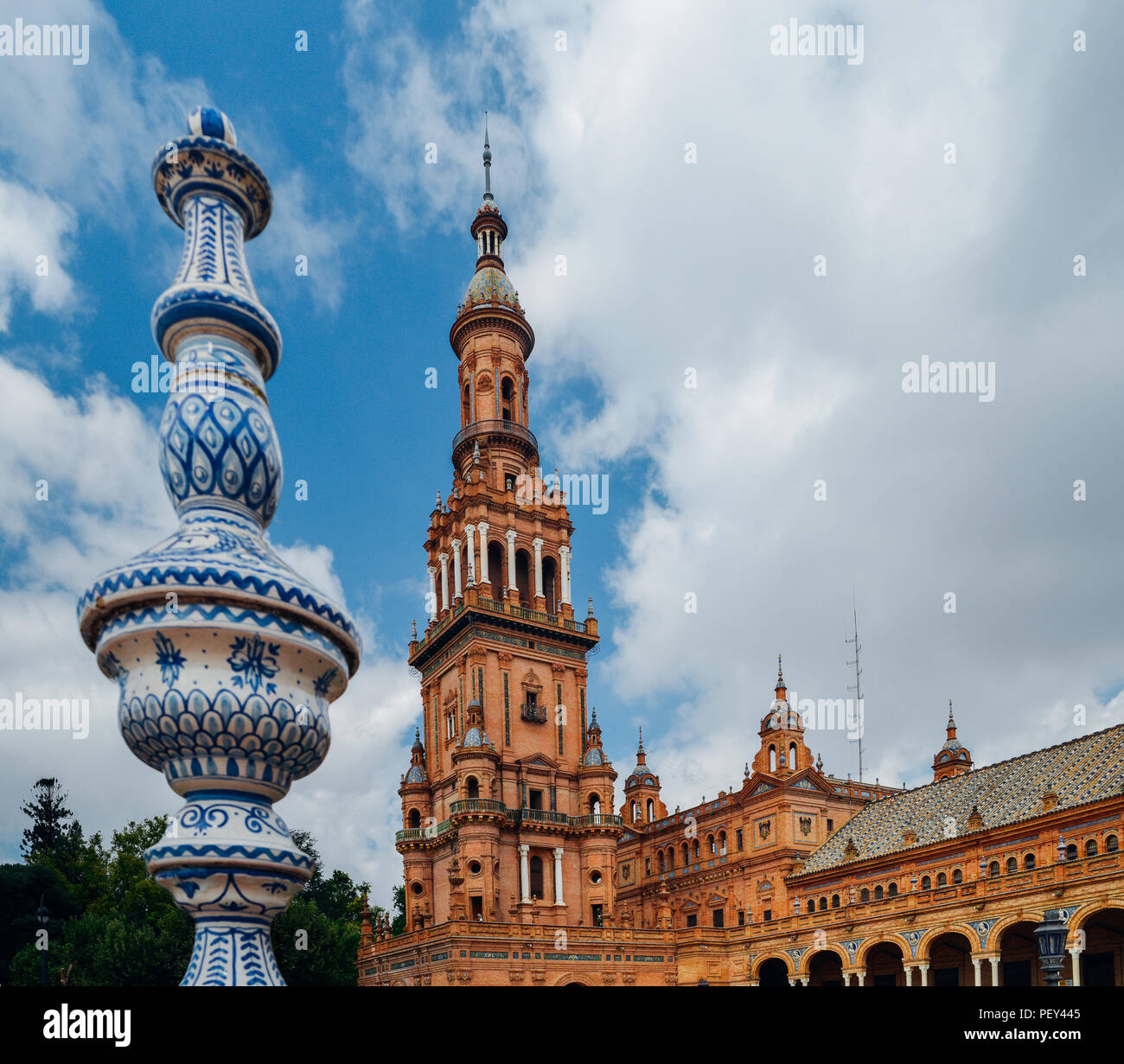 Sevilla Spanien - 15. Juli 2018: Gegenüberstellung von blau und weiß Keramik Azulejo Kacheln gegen eine der barocken Sandstein Turm an der Plaza de Espana in Stockfoto