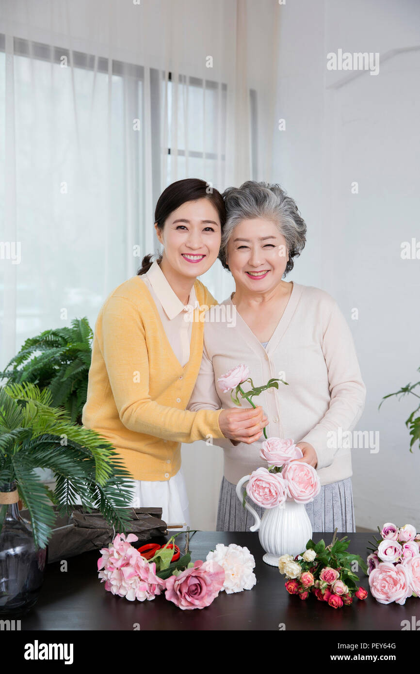 Ältere Mutter und Tochter die Blumendekoration auf Tisch. 036 Stockfoto