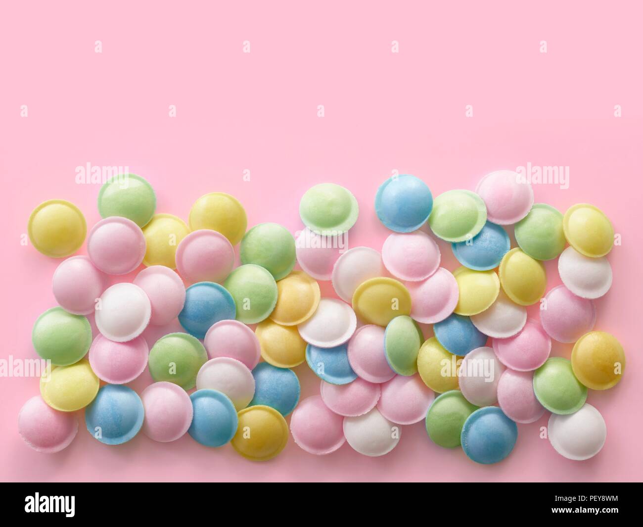 Pastellfarben Süßigkeiten gegen einen rosa Hintergrund gefärbt. Stockfoto
