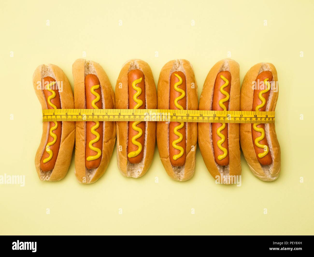 Das Nähren, konzeptionelle Bild. Maßband um Hot Dogs. Stockfoto