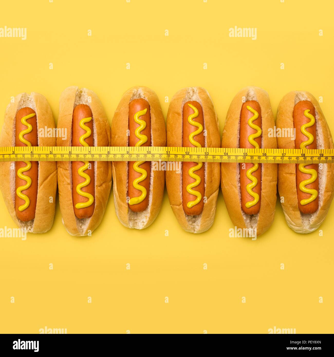 Das Nähren, konzeptionelle Bild. Maßband um Hot Dogs. Stockfoto