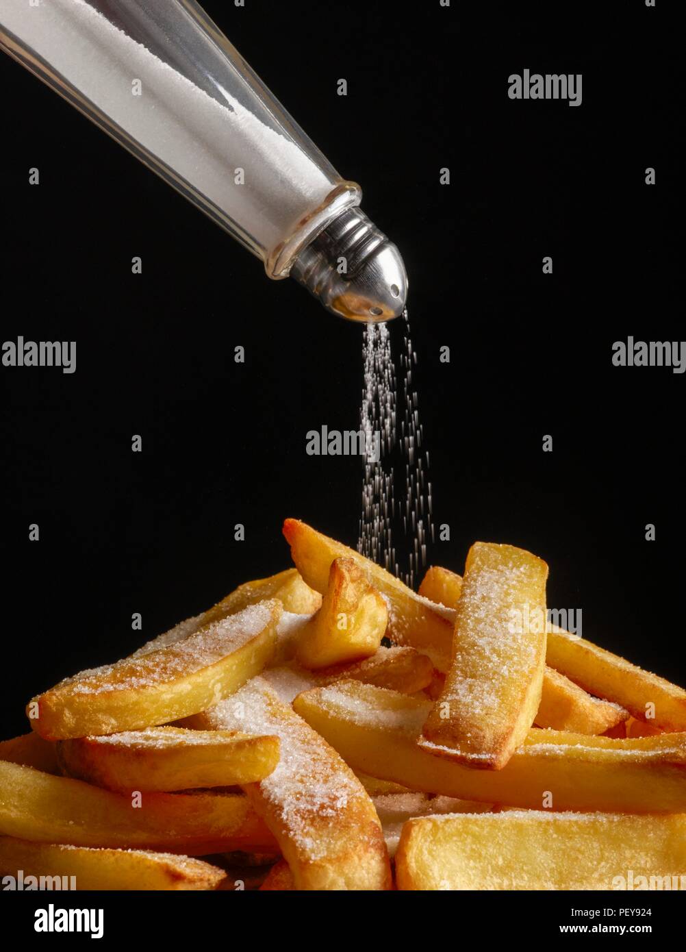 Salz Gießen auf Chips. Stockfoto