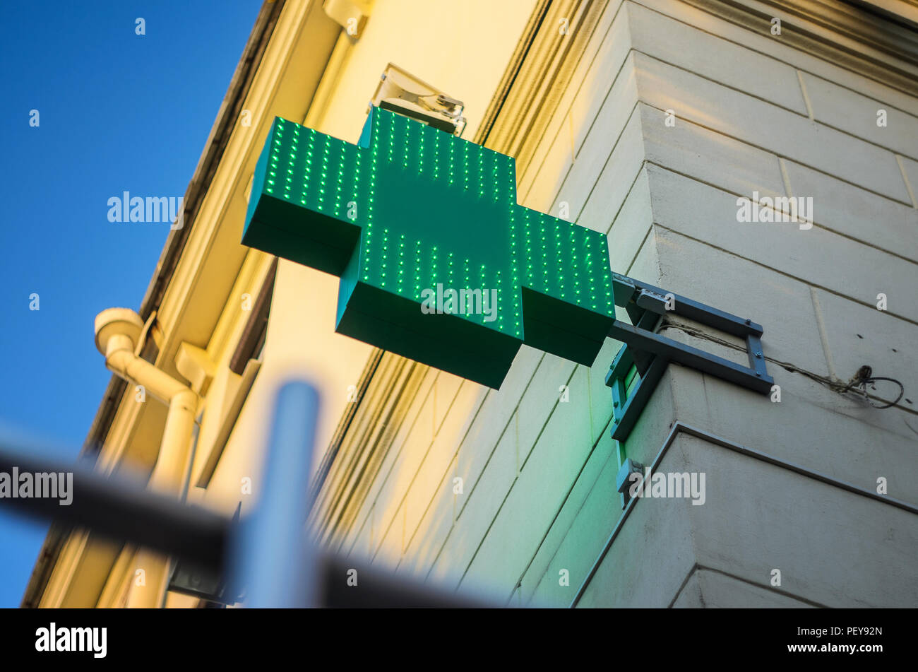 Apotheke mit grünen LEDs auf der Fassade Wand während des süssen Sonnenuntergang Stockfoto