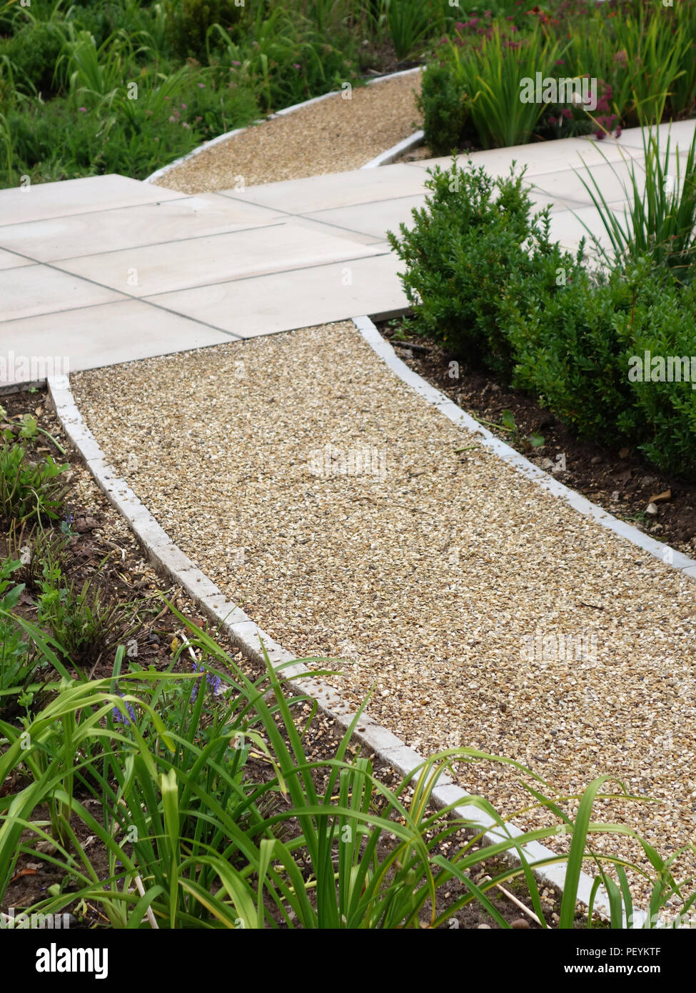 Moderne Steinplatten bilden Wege um einen formalen Garten eines englischen Country Home. Eigenschaft freigegeben Stockfoto