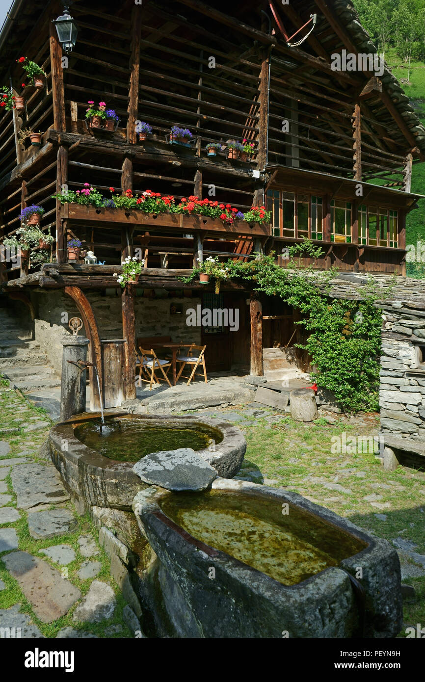 Dorf Wold mit alten Walser Haus andstone Brunnen in der Nähe der Stadt Alagna, Verbania, Piemont, Italien Stockfoto