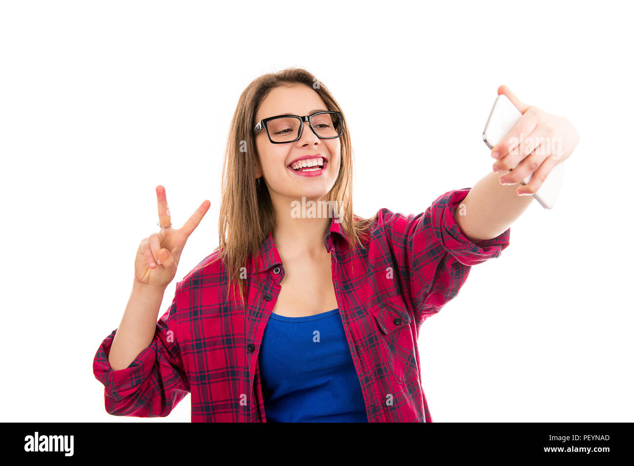 Charmante junge moderne Frau, v-Zeichen und unter selfie mit Smartphone auf weißem Hintergrund Stockfoto