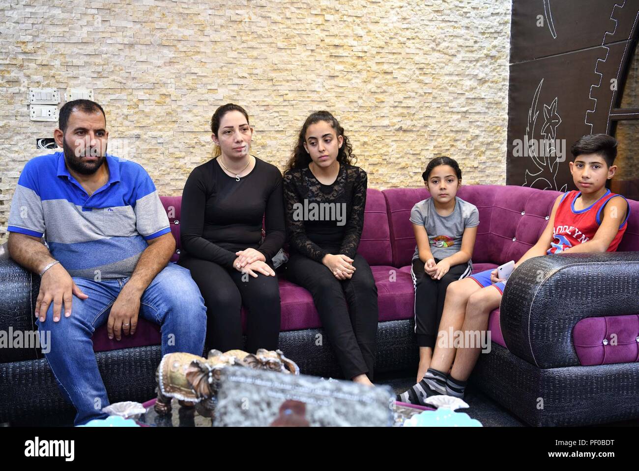 Sweida, Syrien. 15. August 2018. Foto am 15 August, 2018 zeigt Hanin Jibai (C), 17, der einen Angriff durch den Islamischen Staat überlebt (ES) Aktivisten auf ihrem Haus im Dorf Shibki, östliche Landschaft von Sweida Provinz Syrien, am 25. Juli zusammen mit ihrem Onkel und seiner Familie. Hanin Jibai lebt mit ihrem Onkel nach dem Verlust ihrer Mutter und zwei Schwestern im Angriff ist. Shibki Village ist eines der fünf Dörfer die Militanten ist am 25. Juli in Sweida Landschaft in der Nähe der Wüste angegriffen. Der Angriff war der größte in Sweida seit Beginn der Syrischen Stockfoto