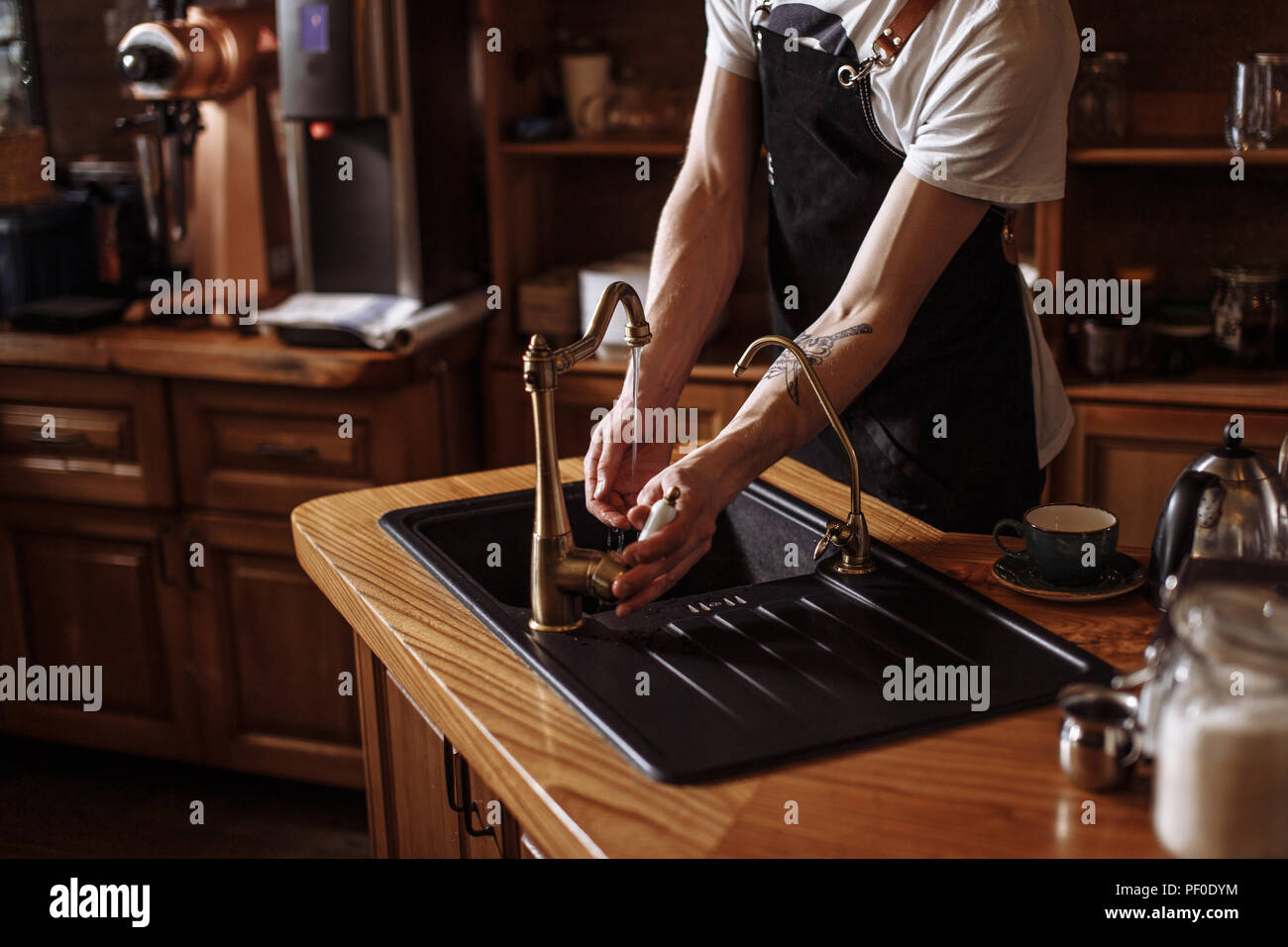 Porträt der jungen Kellner wäscht seine Hände in der Küche im Cafe. Bis 7/8 schließen Foto Stockfoto