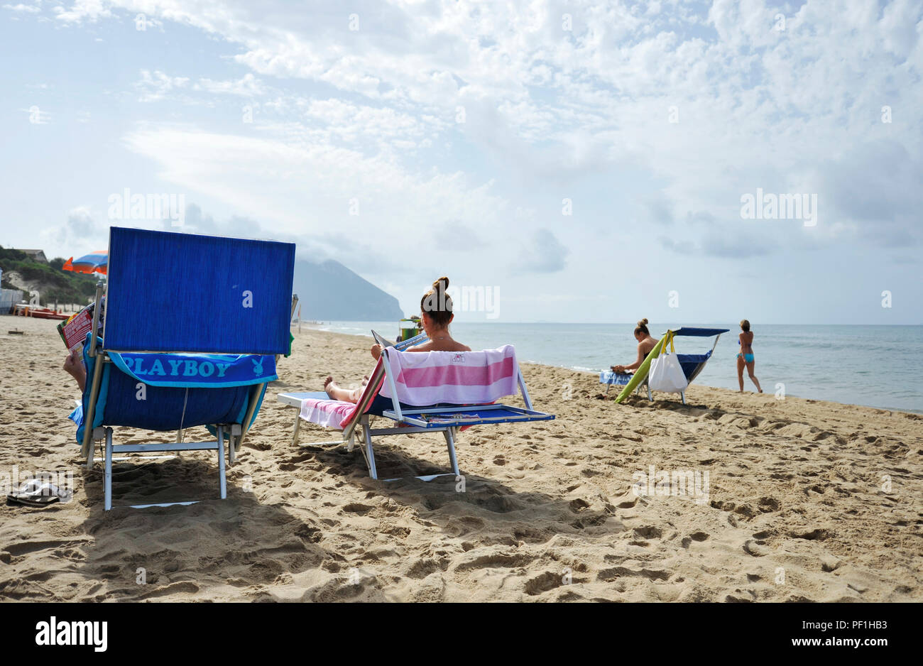 Sabaudia, Latium, Italien - 19 September 2017: Frauen am Strand entspannen durch Lesen klatsch Zeitschriften. Stockfoto