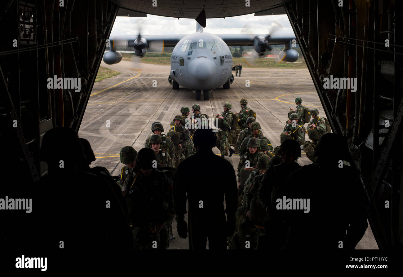 Portugiesische Fallschirmjäger besteigen am 25. Februar 2016 eine C-130J Super Hercules der 37th Airlift Squadron und eine C-130H Hercules der Royal Netherlands Air Force während der Übung Real Tau 16 in Beja, Portugal. Die Übung demonstriert den gemeinsamen Flugbetrieb in den USA und den Niederlanden, indem über 100 Fallschirmjäger in die Luft geworfen werden, und betont taktische Koordination, Interoperabilität und Frachtumschlag. Der C-130J verfügt über verbesserte Motoren und Avionik für verbesserte Leistung. Stockfoto
