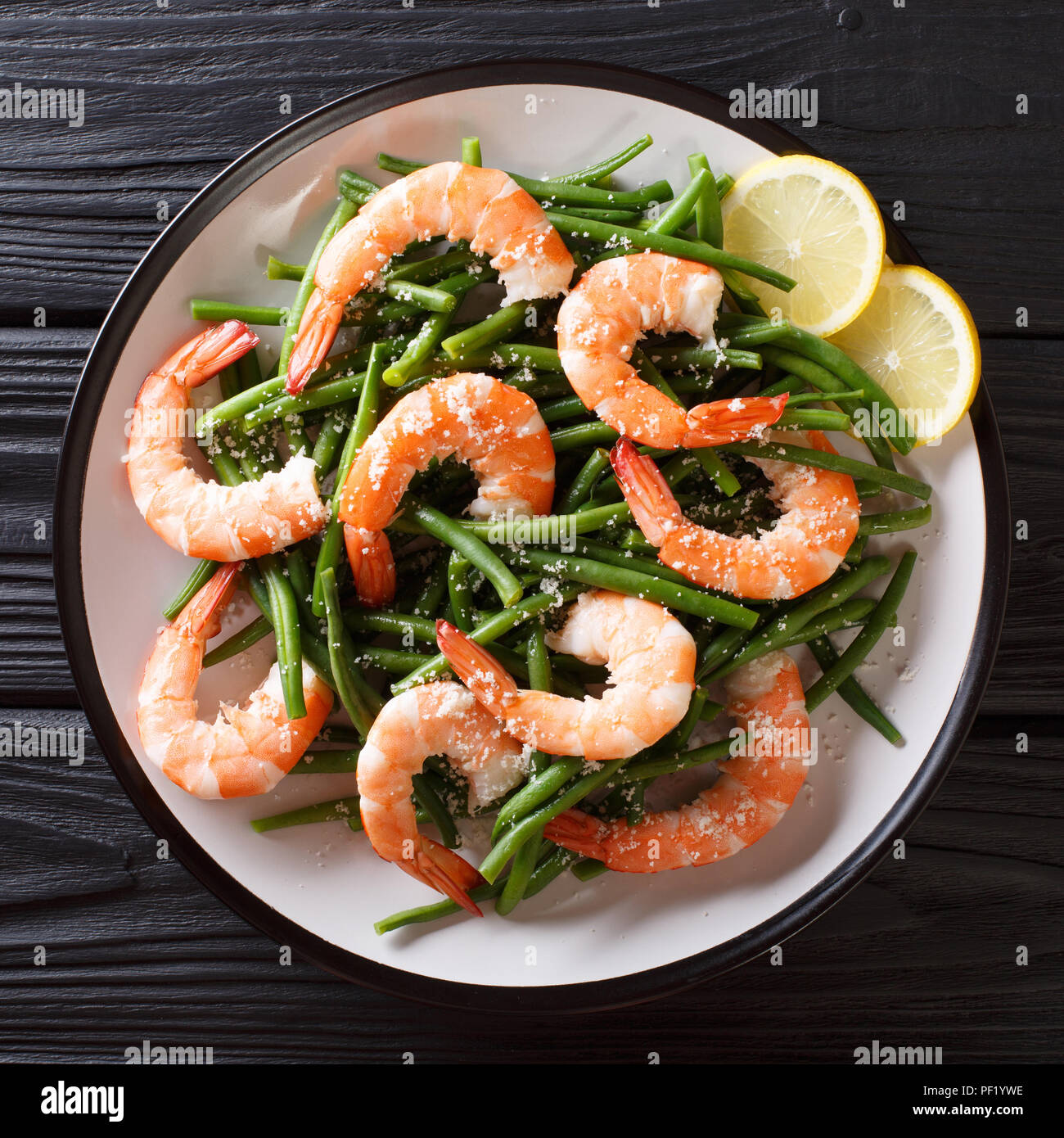 Köstliche Garnelen Salat mit grünen Bohnen, Käse und Zitrone close-up auf einem Teller auf den Tisch. nach oben Ansicht von oben Stockfoto
