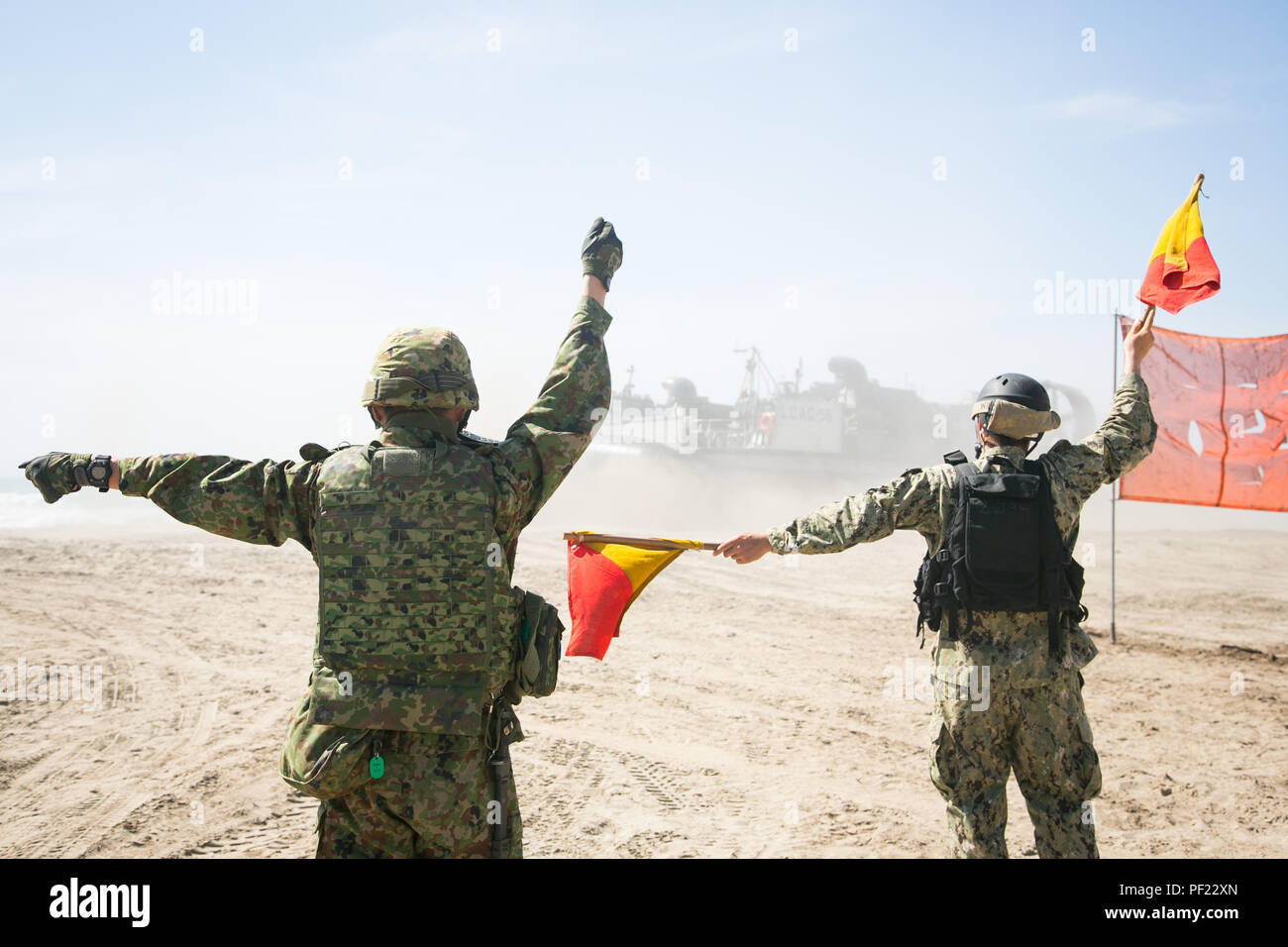 Marine Seaman Josua Alderette, Strand Master Unit 1 (BMU-1), und Kapitän Yosuke Abe, Westliche Armee Infanterie Regiment, Japan Masse Verteidigung-kraft, Guide eine Landing Craft air cushion (LCAC) von der Küste nach dem Einlegen Personal und Ausrüstung, während amphibische Landung Übung (PHIBLEX) für Übung Iron Fist 2016 an Bord der Marine Corps Base Camp Pendleton, Calif., Feb 26, 2016. LCACs sind Auslandseinsätze amphibischen Fahrzeugen verwendet, um große Waffen, militärische Fahrzeuge und Personal zu transportieren. (U.S. Marine Corps Foto von Cpl. Xzavior T. McNeal/Freigegeben) Stockfoto