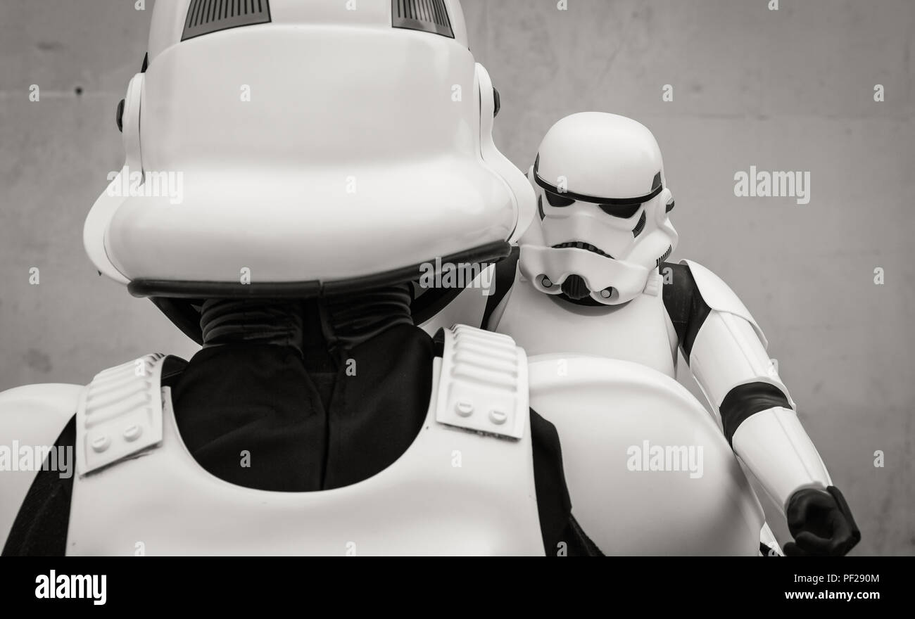 Eine männliche Cosplayer gekleidet wie ein Stormtrooper aus dem Star Wars franchise Holding ein Stormtrooper Spielzeug fest in ein lustiger Vater und Sohn lifestyle Bild. Stockfoto