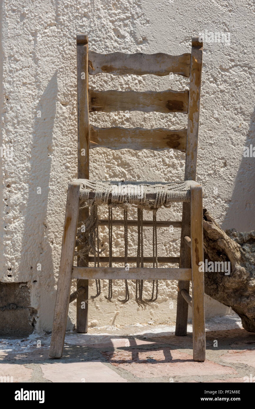 Eine wackelige, alte abgenutzte antiker Stuhl mit einem korbsieb Sitz. Stockfoto