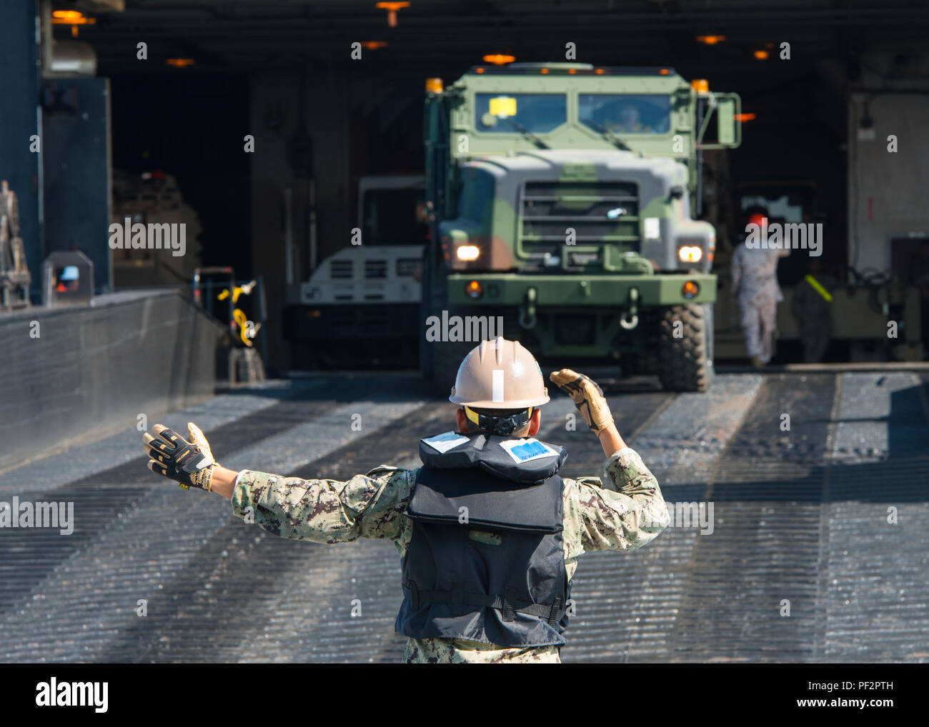 160119-N-KK 081-916 US-Flotte 5 BEREICH DER OPERATIONEN (Jan. 19, 2016) - Ausrüstung Fahrer 3. Klasse Emilano Gutierrez, angeschlossen an Amphibious Construction Battalion (ACB) 1, führt ein Medium taktische Ersatzfahrzeug aus dem Militärischen Sealift Command ship USNS 1 ST LT Baldomero Lopez (T-AK3010) auf die Roll-on/Roll-off-Entlastung facility Plattform während einer Übung in den USA 5 Flotte Bereich der Operationen. Military Sealift Command Schiffe USNS 1 ST LT Baldomero Lopez (T-AK 3010) und USNS Pililaau (T-AKR 304) in einem Navy, Marine Corps und der Armee gemeinsame Maritime Vorpositionierung Force vertreten war ausgeschaltet Stockfoto