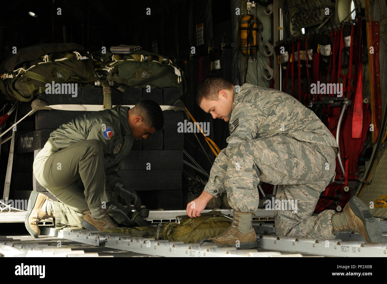 Us Air Force Tech. Sgt. Jimmy Sealey, II, (links), Staff Sgt. Henry Fowler, 156 Airlift Squadron loadmasters, sicher eine Palette und Fallschirm auf der C-130 Hercules Flugzeuge auf der North Carolina Air National Guard Base, Charlotte Douglas International Airport, N.C., Feb 6, 2016. Beide loadmasters sind Teil eines MAX Formationsflug und Air Drop Training Mission an der Stanley County Airport, New London, N.C., die jedes Flugzeug und Paletten an die 145 Luftbrücke Flügel zugeordnet. (U.S. Air National Guard Foto: Staff Sgt. Julianne Showalter) M. Stockfoto