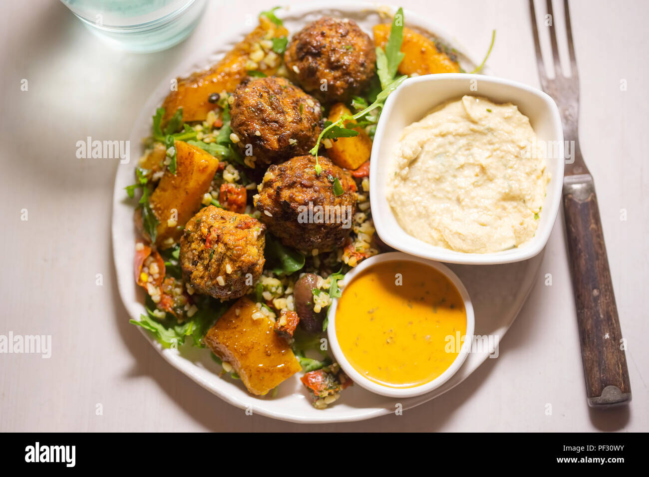 Felafels mit Bulgur, Rakete, Blätter, butternut Kürbis Salat & Stil Houmous & tahini Zitrone Dressing Stockfoto