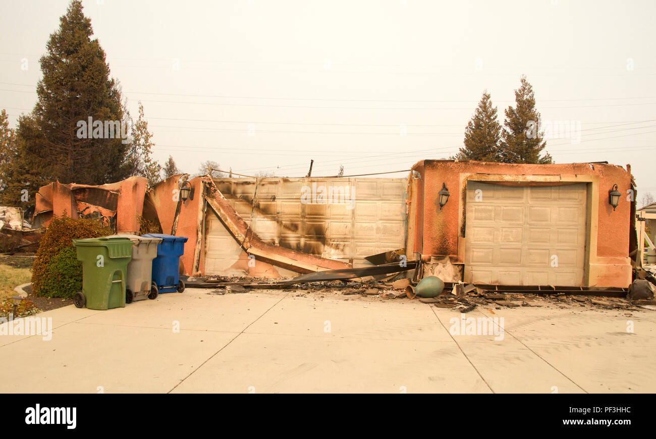 Home streng mit schiefen Wände und Stuck hängen in der letzten wilden Feuer Feuer Sturm in Redding, Kalifornien verbrannt. Rauch und Asche in der Luft, als der Stockfoto