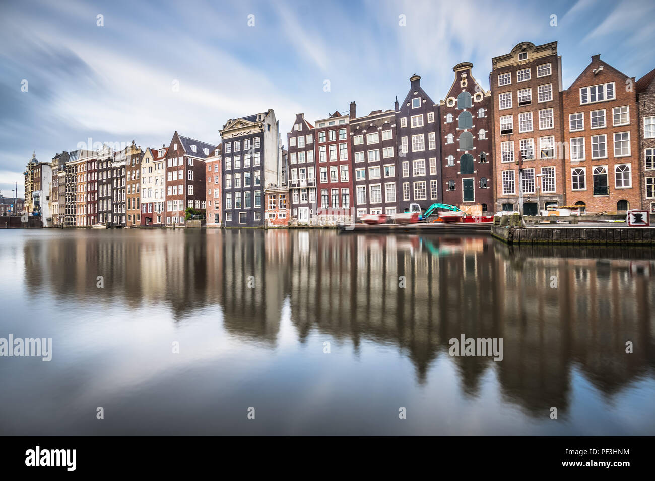 Am Abend Blick auf die 'Dancing Häuser der Damrak, iconic canal Häuser in der Hauptstadt Amsterdam. Stockfoto