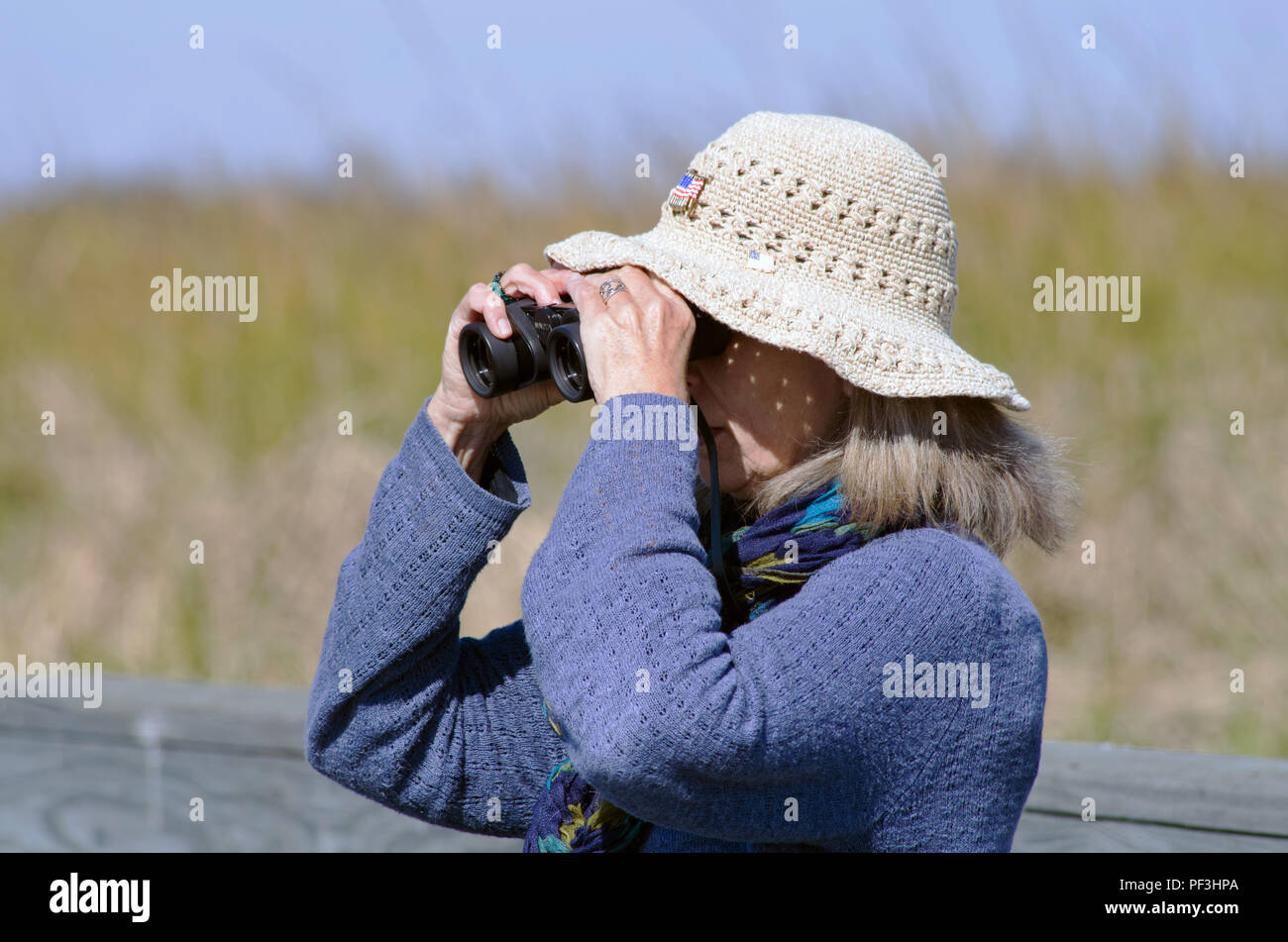 Eine Frau, die mit dem Fernglas views Wildlife am zum Beispiel: Leonabelle Turnbull Birding Center in Port Aransas, Texas USA. Dieser Standort ist in der Nähe von Corpus Christi. Stockfoto