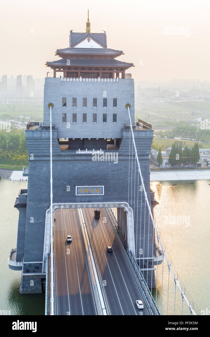 Yangzhou, Jiangsu, China. Brücke über den Fluss Liao Jia Gou. Industrielle Dunst in der Ferne, am späten Nachmittag. Stockfoto