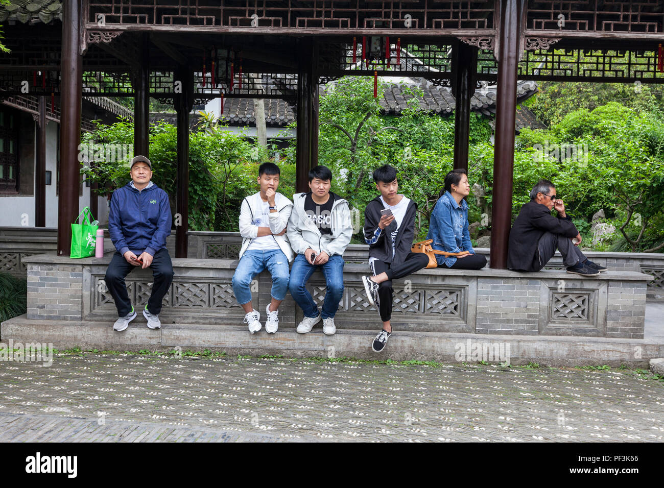Yangzhou, Jiangsu, China. Schlanke West Lake Park. Junge Männer und andere Ruhen, legere Kleidung. Stockfoto