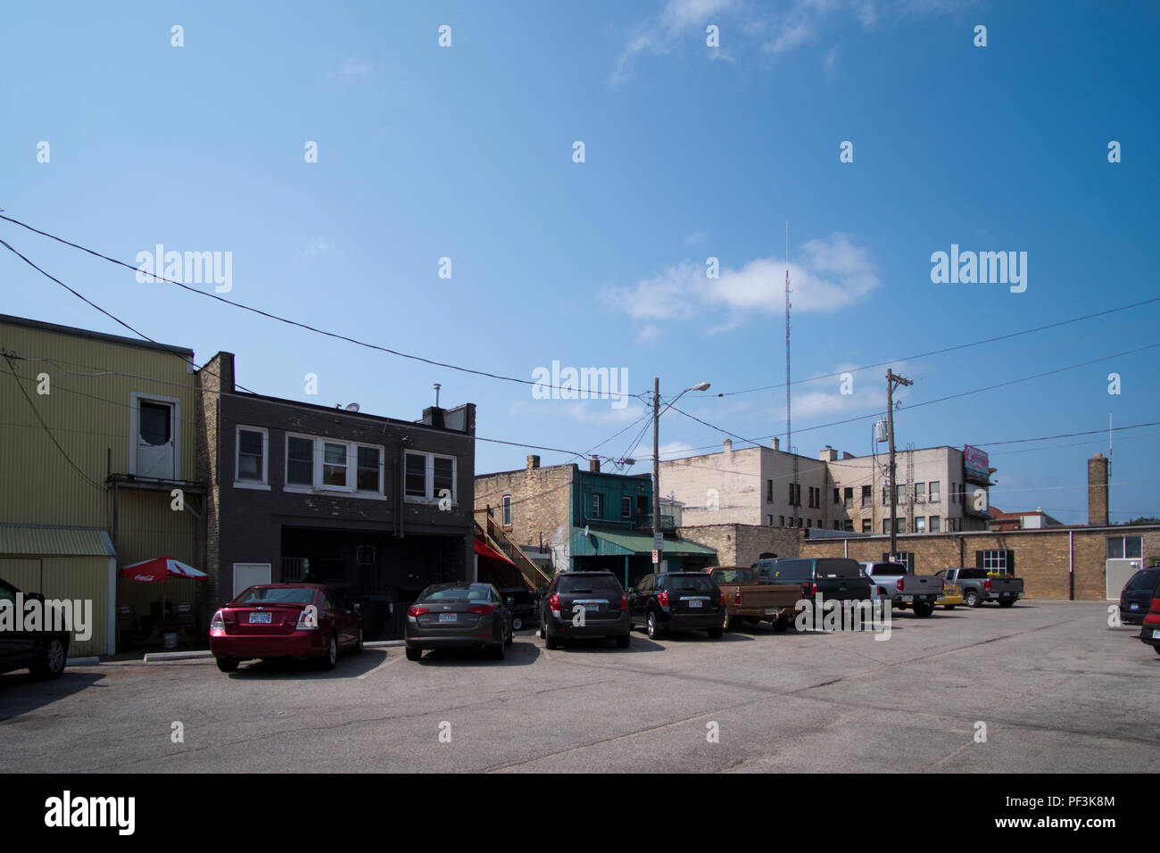 Gasse und Parkplatz hinter einer Reihe von Einzelhandelsunternehmen in der Innenstadt von Ludington, Michigan, USA. Stockfoto
