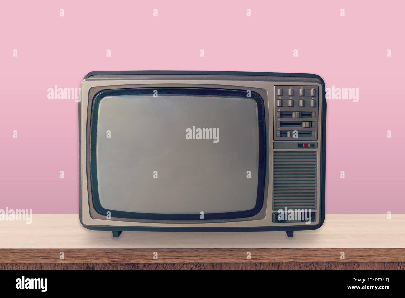 Vintage TV Box auf Holztisch und Rosa pastellfarbenen Hintergrund. Stockfoto