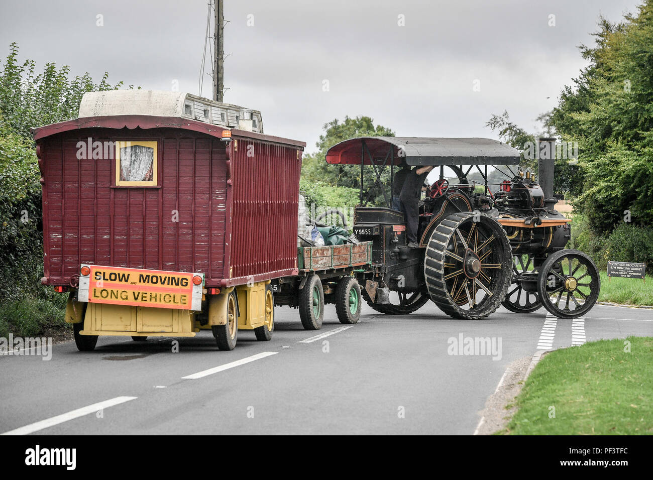 Eine Zugmaschine schleppt einen Wohnwagen als Dutzende von Dampf angetriebene Fahrzeuge ihren Weg durch die Dorset zum Great Dorset Steam Fair, wo Hunderte von Zeitraum dampfbetriebene Zugmaschinen und schwere mechanische Ausrüstung aus allen Epochen für die jährlichen Erscheinen am 23. bis 27. August 2018 zu sammeln, zu 50 Jahren feiern. Stockfoto