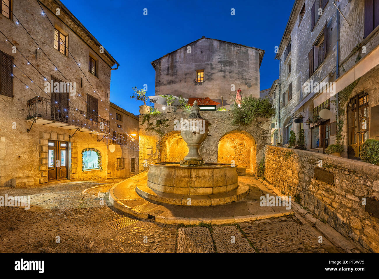 Berühmten Brunnen (La Grande Fontaine de 1850) bei Einbruch der Dunkelheit in Saint Paul de Vence, Alpes-Maritimes, Frankreich Stockfoto