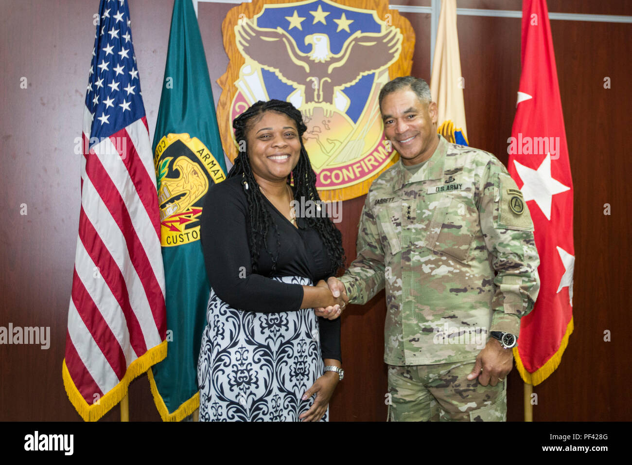 Us-Armee Generalleutnant Michael X. Garrett, US-Army Central Commander, präsentiert eine Münze zu Frau Claudette Smith, ein Beschaffung Analytiker für Certified Scrum Product Owner, im Camp Arifjan, Kuwait, 10. August 2018. Abteilung der Armee Zivilisten sind entscheidend für den Erfolg von USARCENT's Mission. (U.S. Armee Foto von Sgt. Fatima Konteh) Stockfoto