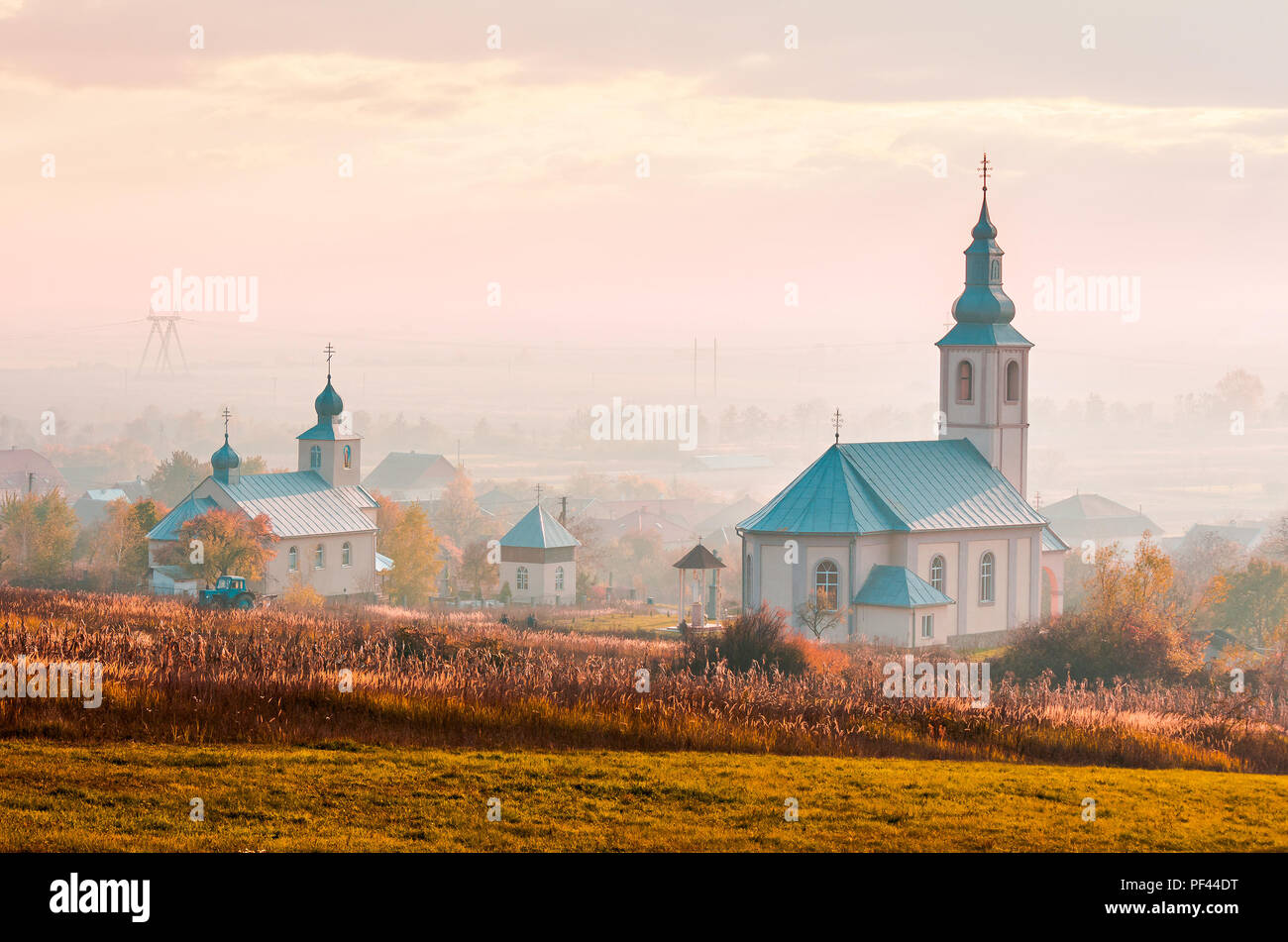 Katholische und orthodoxe Kirchen bei Nebel Sonnenaufgang. schöne Landschaft Landschaft im Herbst. Kreative toning Stockfoto