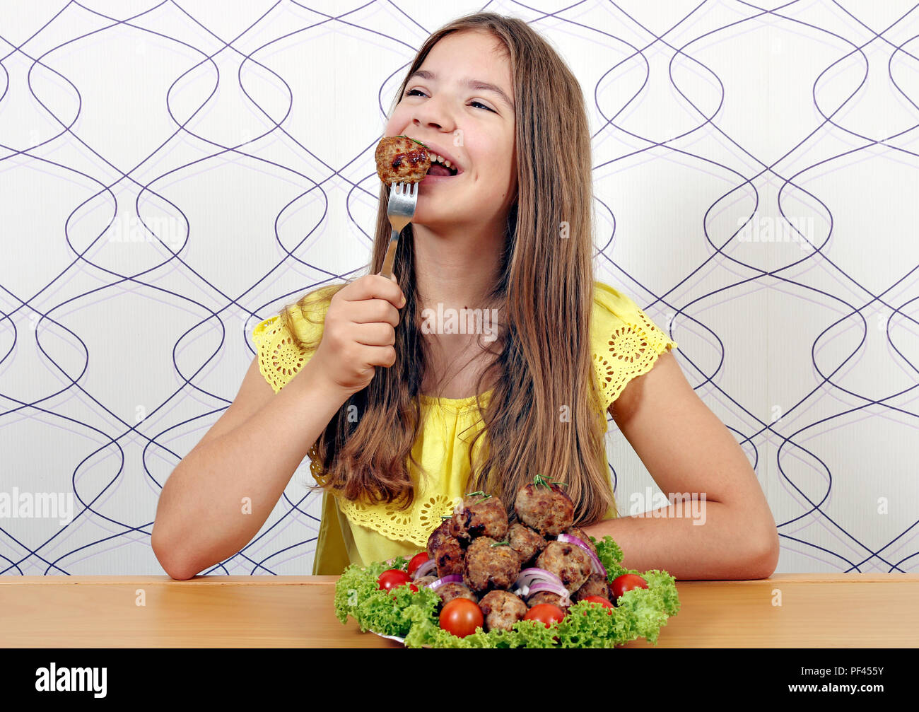 Schöne glückliche Mädchen isst Frikadelle Stockfoto