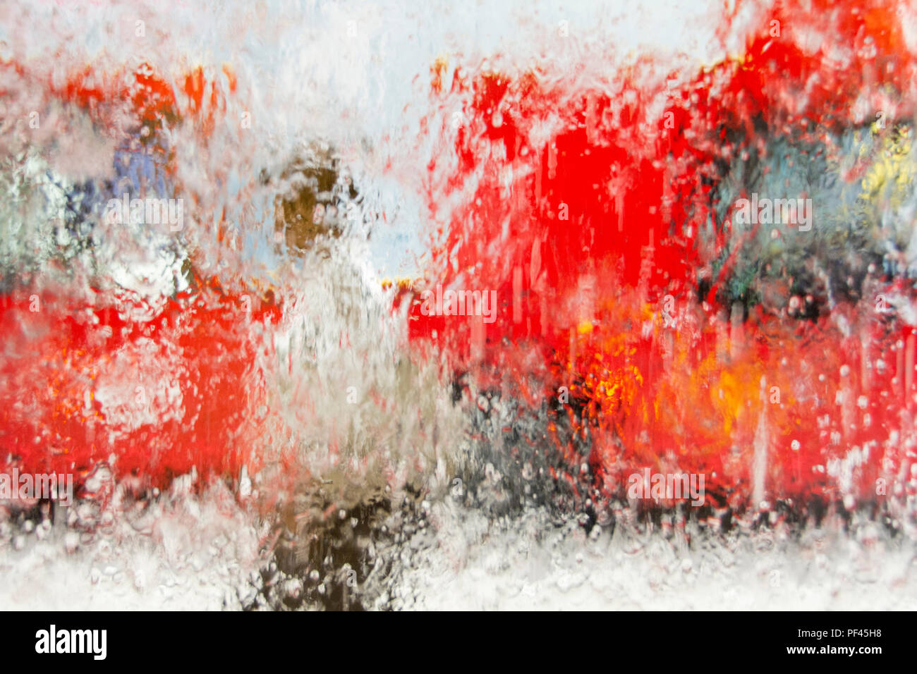 Mann vor einem Transport for London red Bus - wässrige Abstrakt Hintergrund Stockfoto