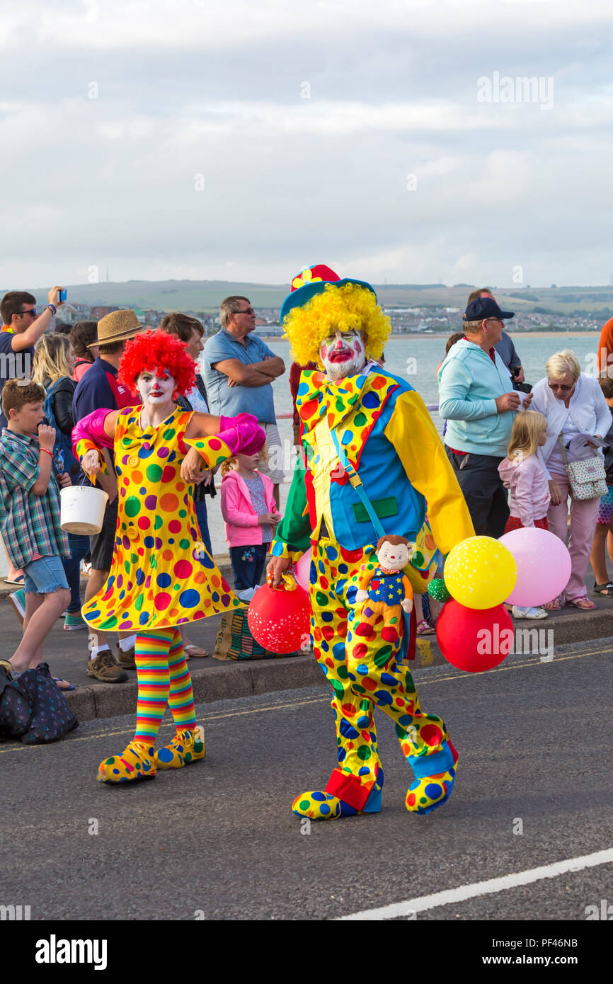 Bunte Clowns, die sich an der jährlichen Karnevalsumzug Parade von Weymouth, Dorset UK im August Stockfoto