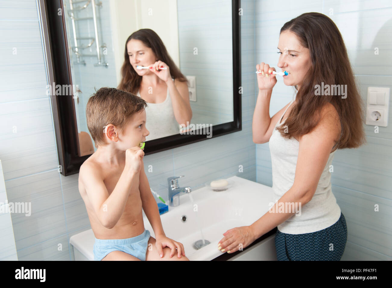 Familie Mutter und gesundes Kind Zähneputzen in Bad am Morgen Stockfoto
