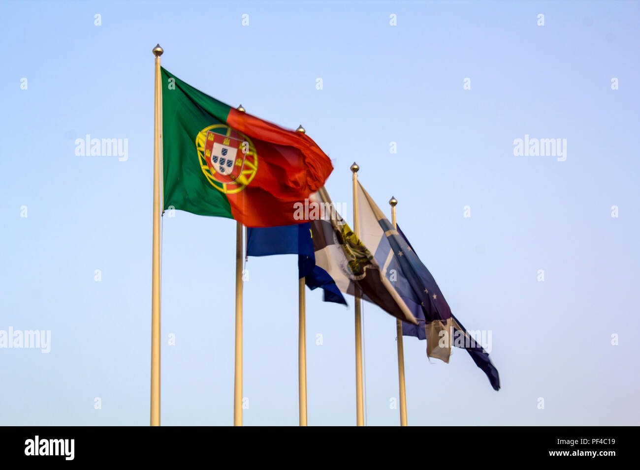 Portugiesische Flagge schwenkten gegen den blauen Himmel Stockfoto