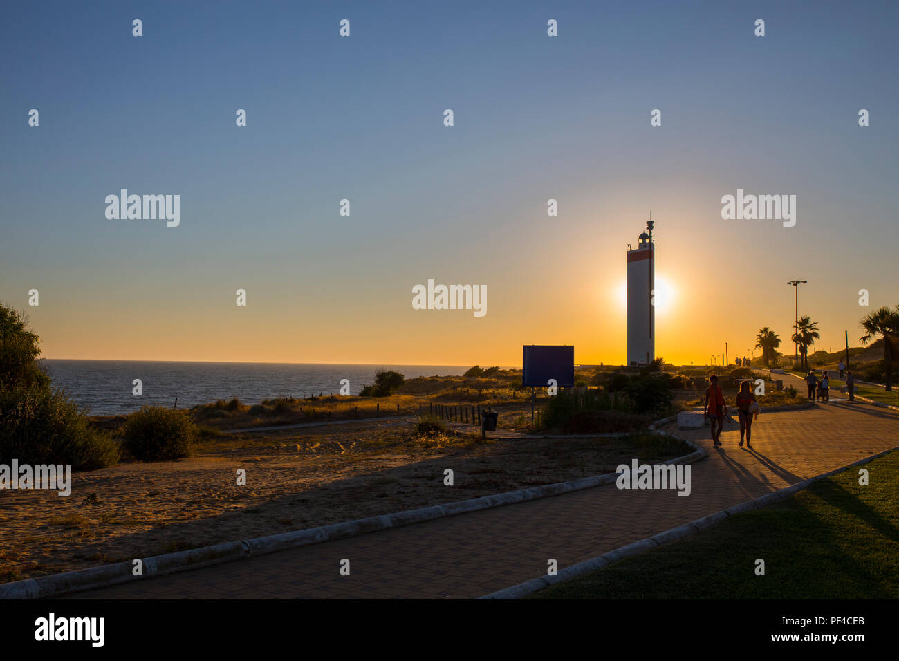 Menschen zu Fuß von Matalascanas Promenade entlang der Leuchtturm, Almonte, Huelva, Spanien Stockfoto