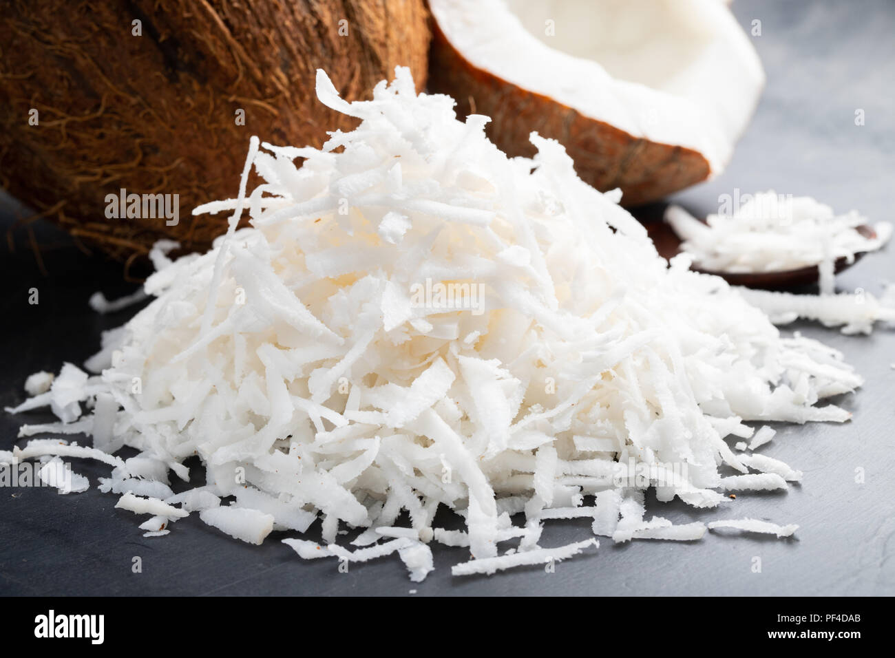 Frische Kokosnuss Flocken auf schwarzem Hintergrund. Stockfoto