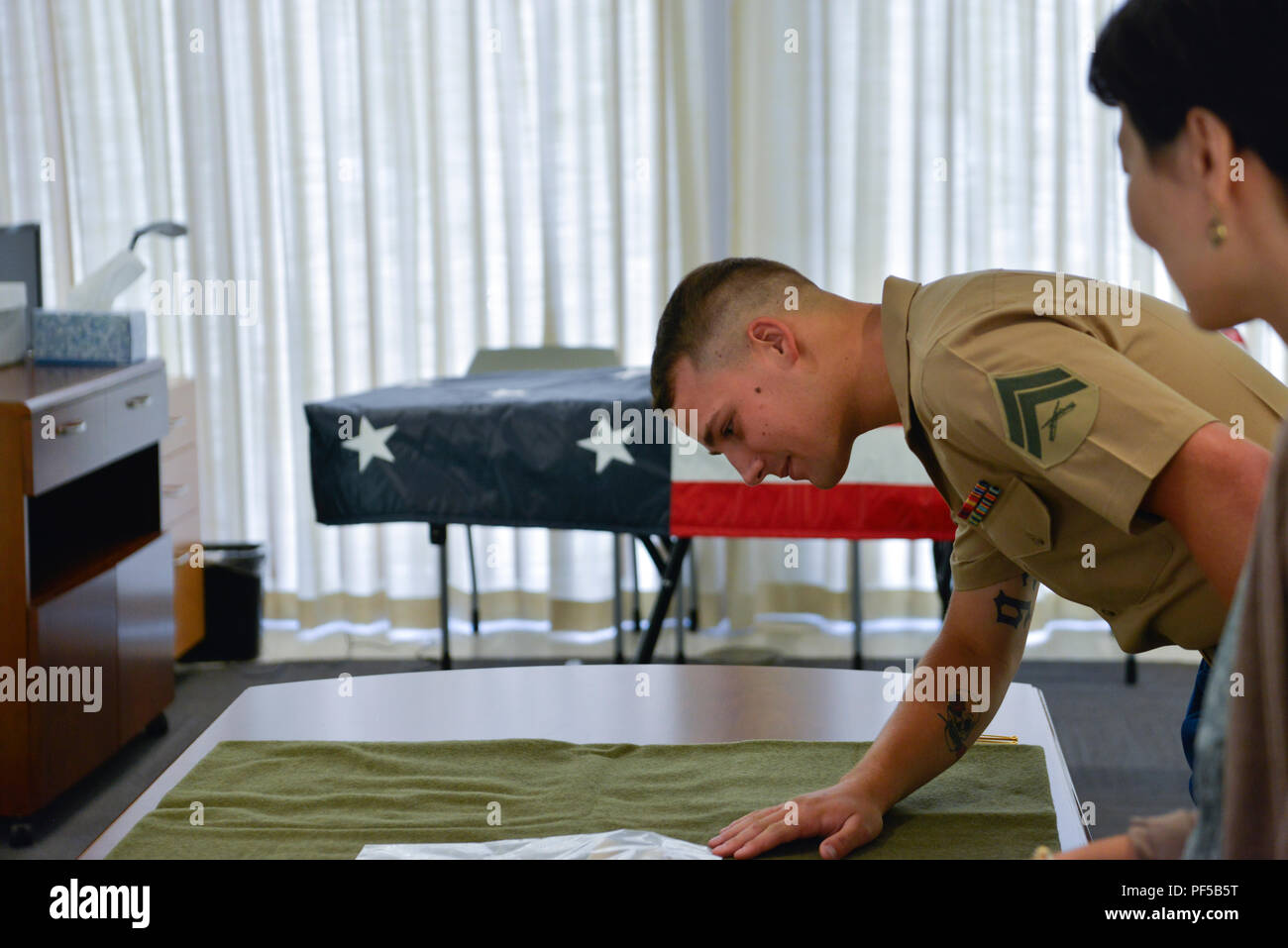 Us Marine Corps Cpl. Nathaniel Walters steht durch die Reste von seinem Großonkel, U.S. Army Pfc. Joe S. Elmore, vor dem Transport während einer Chain of Custody Ereignis im Senator Daniel K. Inouye Kompetenzzentrum auf Joint Base Pearl Harbor-Hickam, Hawaii, Nov. 14, 2018. Walters besuchten die Verteidigung POW/MIA Accounting Agentur (DPAA) Im Rahmen seiner Pflichten als das US-Militär Spezielle Begleitung für seinen großen Onkel bleibt auf dem Weg in die letzte Ruhestätte auf dem Friedhof in der Nähe der Wohnung der Familie in Kentucky. (U.S. Armee Foto: Staff Sgt. Michael O'Neal) Stockfoto