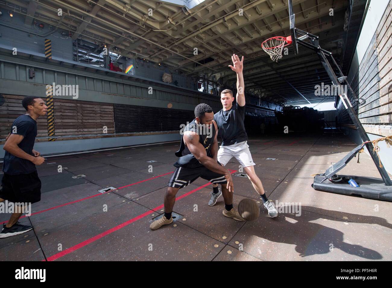 180813-N-GX 781-0131 karibische Meer (Aug. 13, 2018) Segler Basketball spielen in dem Deck der Whidbey Island-Class Dock Landung Schiff USS Gunston Hall (LSD 44). Das Schiff ist auf die Bereitstellung unterstützen, Südsee, das ist eine jährliche gemeinsame Bereitstellung in der US Southern Command Verantwortungsbereich, wo eine Aufgabengruppe bereitstellen werden eine Vielzahl von Übungen und multinationalen Austausch durchzuführen, die Interoperabilität zu verbessern, die regionale Stabilität zu erhöhen, und bauen und regionale Beziehungen mit den Ländern der Region durch gemeinsame, multinationale und ressortübergreifende Austausch pflegen Stockfoto