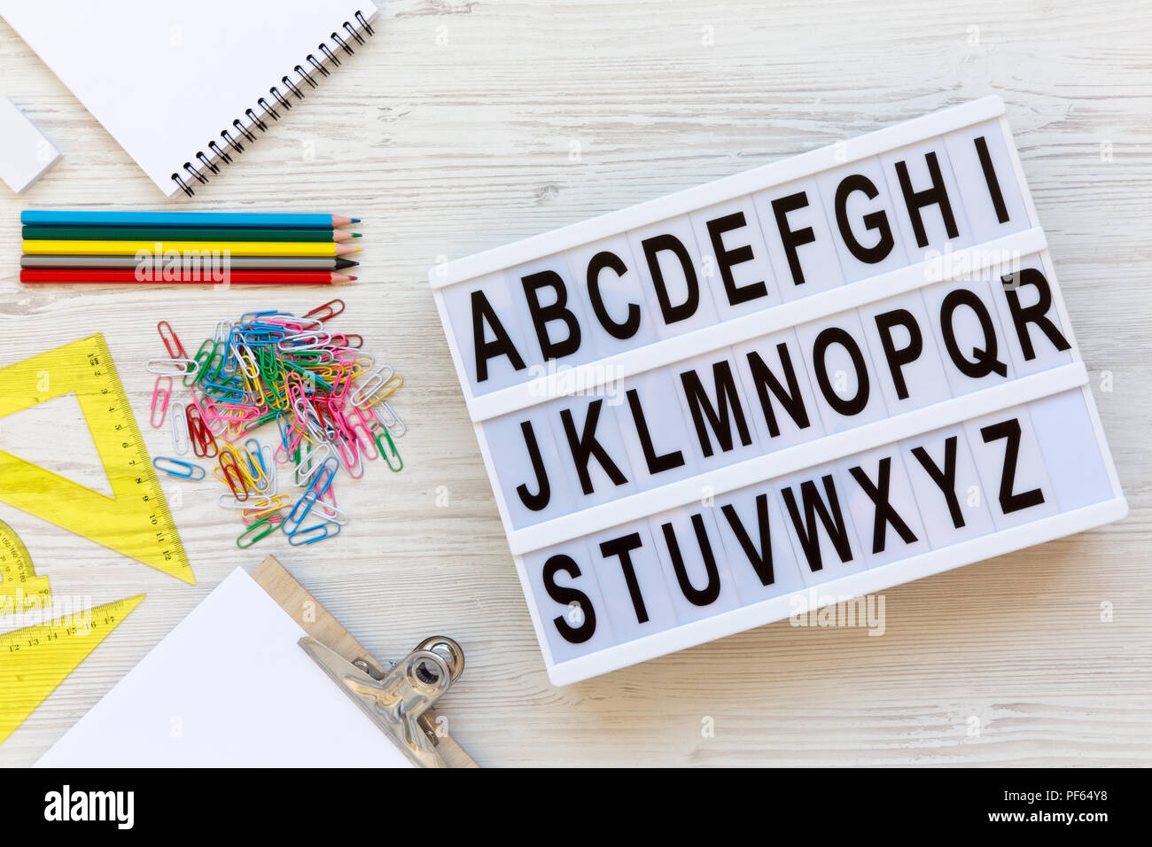 Zurück zum Konzept der Schule. Buchstaben von A bis Z des englischen Alphabets auf modernen Board und Zubehör für Studie über weiß Holz- Oberfläche, Ansicht von oben. Von Stockfoto