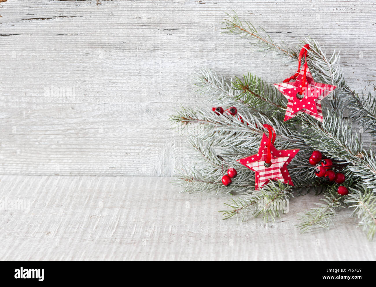 Tanne Zweig mit Weihnachtsschmuck auf weißen Holzmöbeln im Landhausstil Hintergrund. Stockfoto