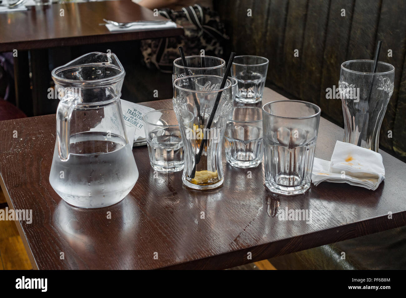Leere Gläser und einen Krug Wasser auf einen Tisch im Restaurant. Stockfoto