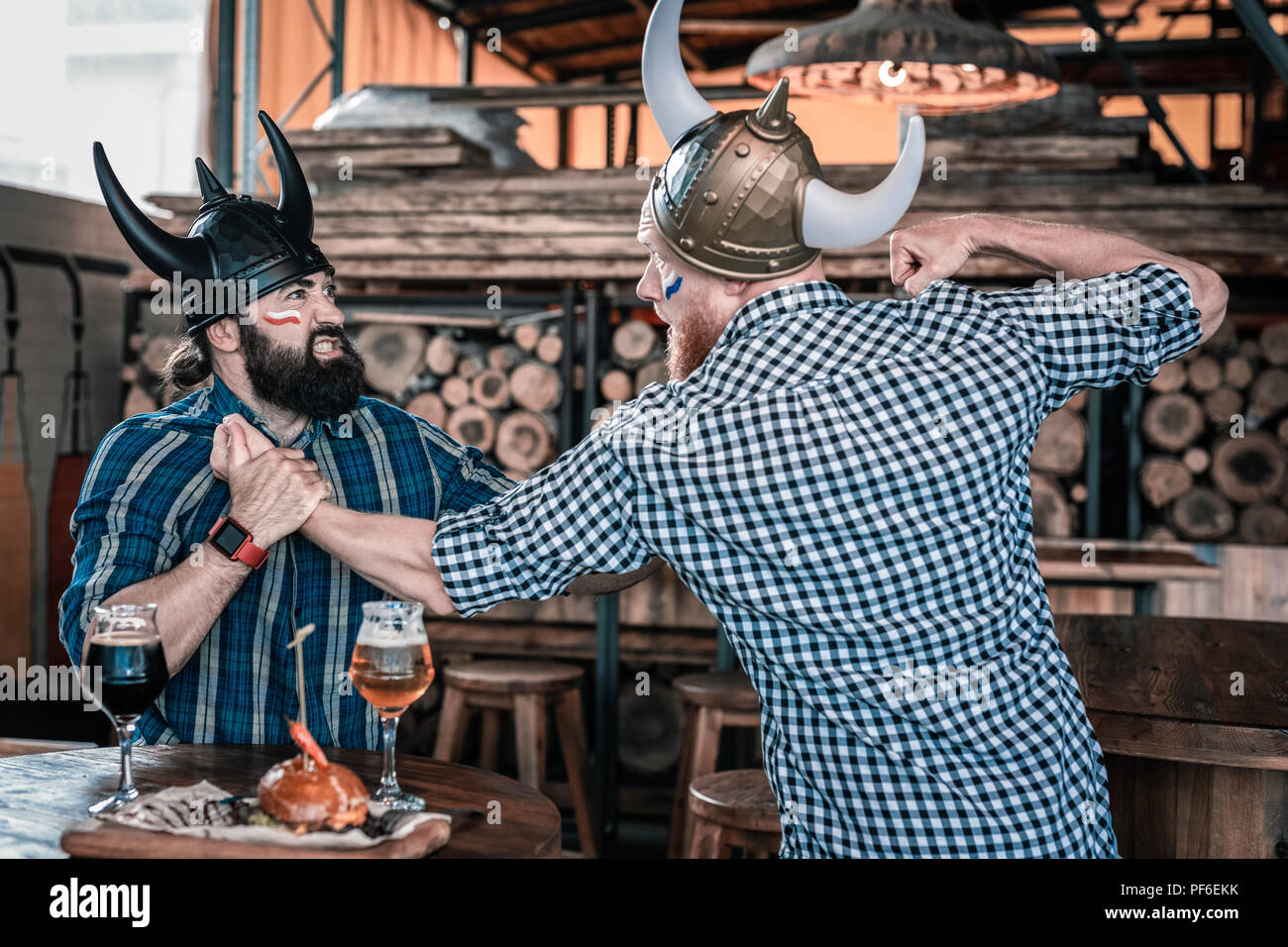 Zwei emotionale Mann mit Viking Hüte in einem Kampf Stockfoto