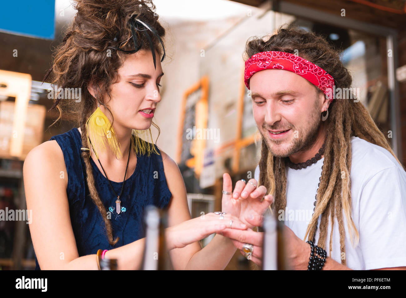 Hippie Mann mit leuchtend roten Stirnband mit Blick auf seine Freundin hand Stockfoto