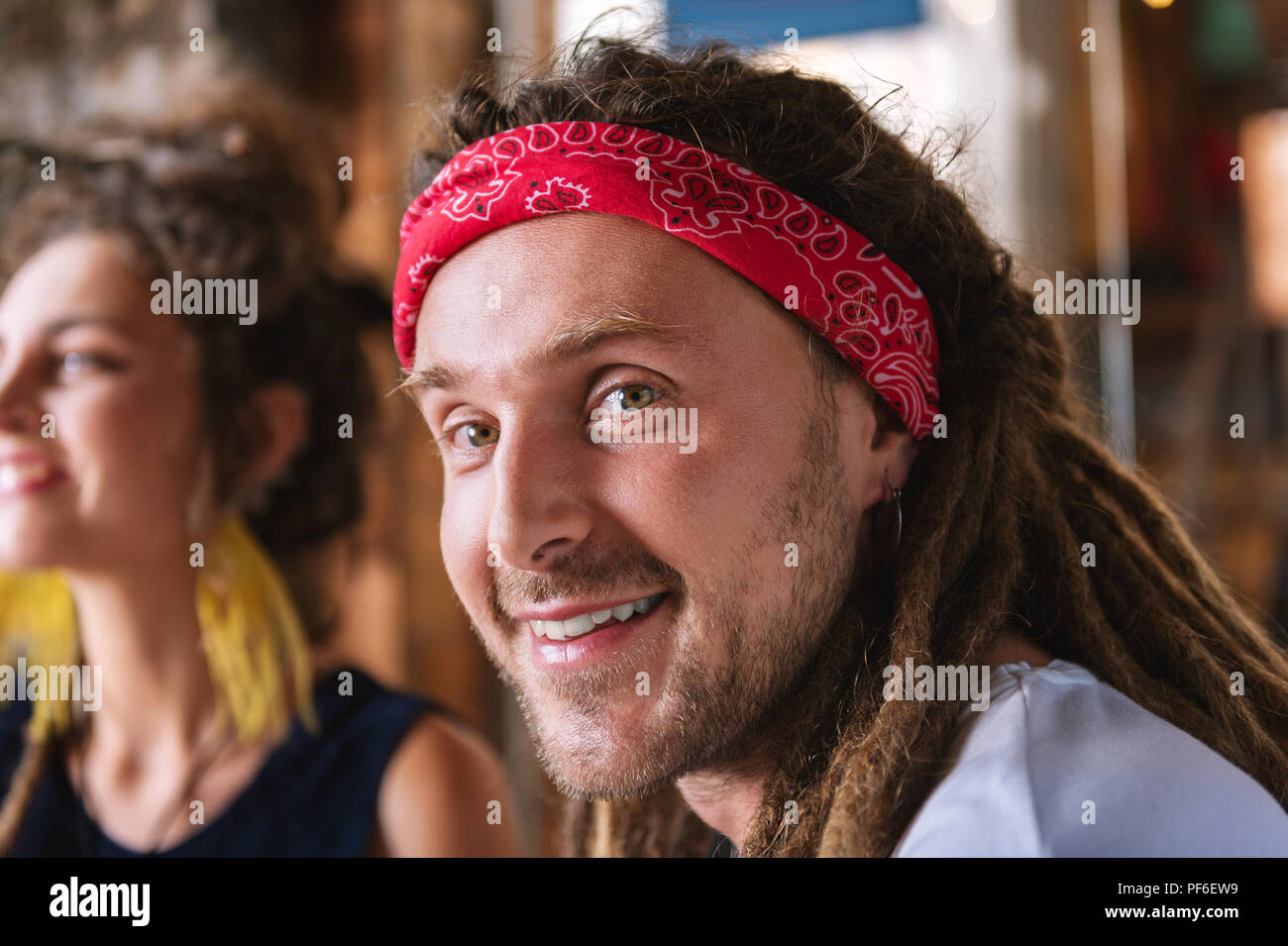 Dunkelhaarige hippie Mann mit schönen Blumen rot Kopfbügel Stockfoto