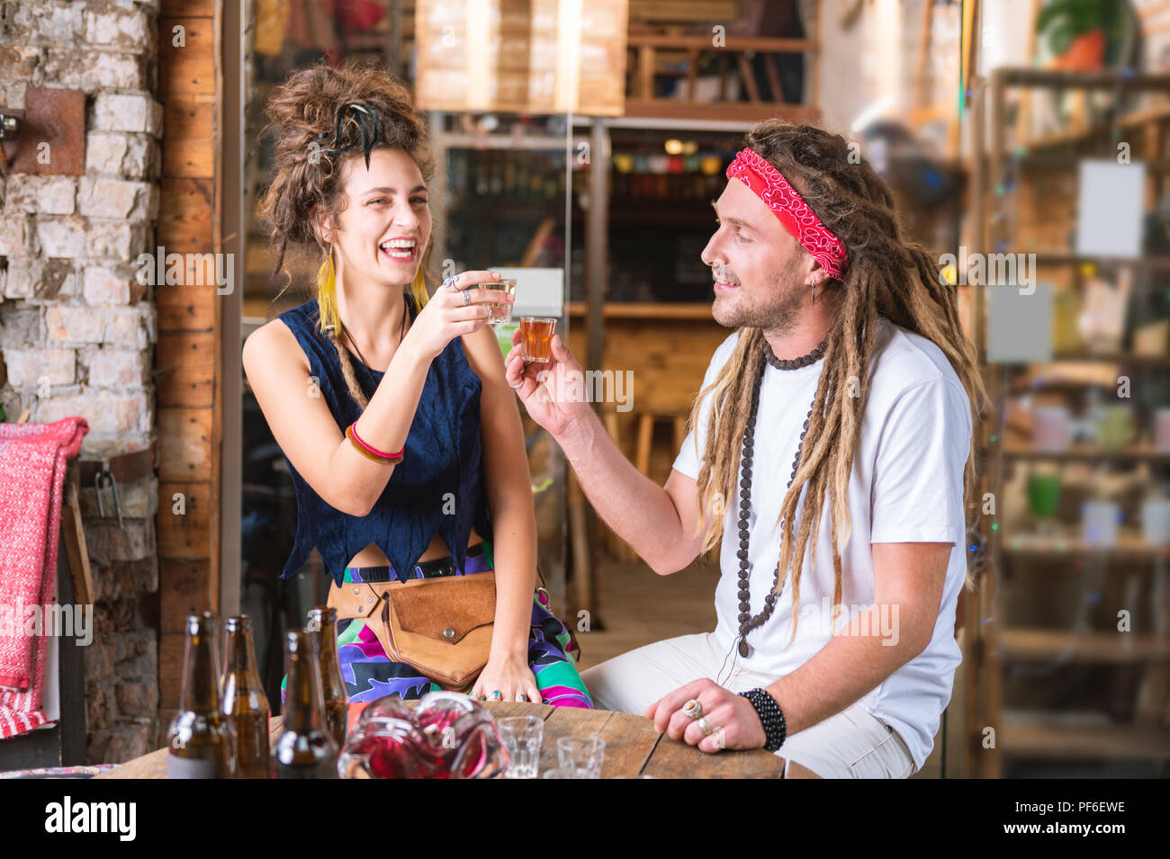 Lachend ein paar Hippies trinken Tequila Hochzeitstag zu feiern Stockfoto