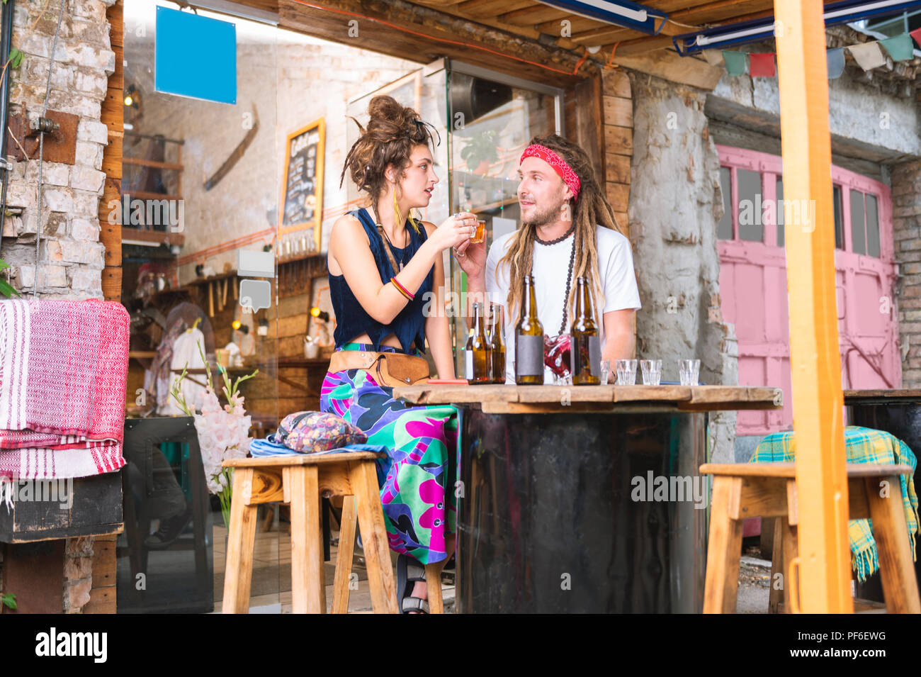 Dunkelhaarige Frau mit langen hellen Rock trinken mit ihrem Mann Stockfoto