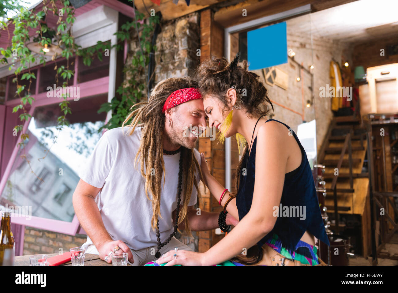 Hippie Mann mit langen Haaren seine schöne Freundin umarmen Stockfoto